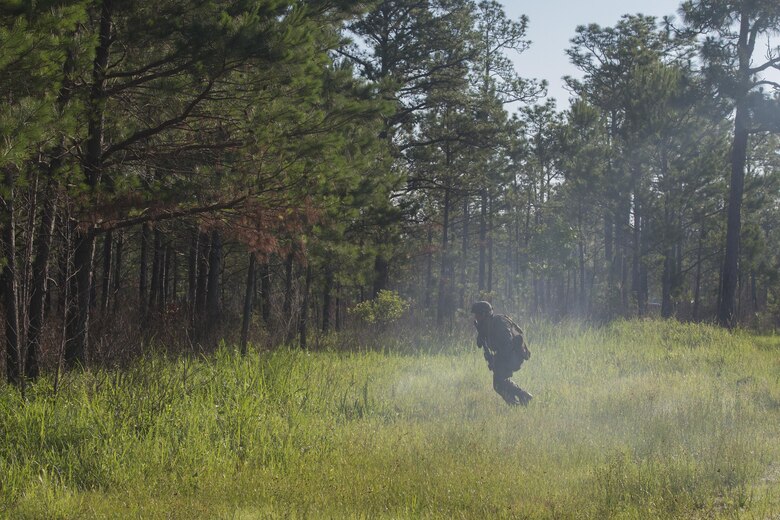 A Marine with 3rd Battalion, 6th Marine Regiment uses the cover of smoke from a simulation artillery round to move into the tree-line during the battalions' Marine Corps Combat Readiness Evaluation, at Camp Lejeune, N.C., May 10, 2016. The MCCRE, a pre deployment exercise, tests the Marines on operational readiness and their ability to operate as a whole.