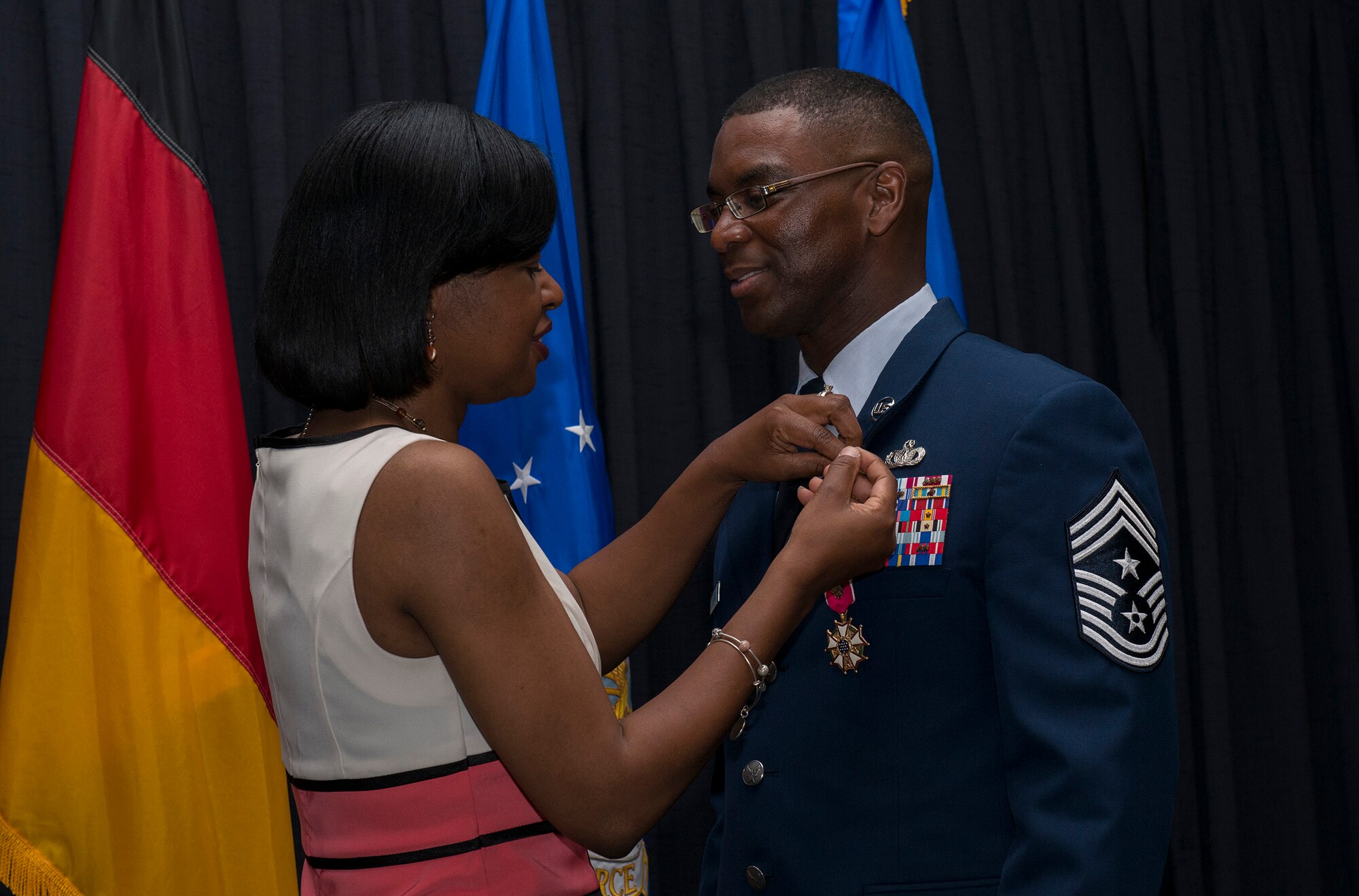 Patricia Davis pins a retirement pin on her husband, Chief Master Sgt. James E. Davis, U.S. Air Forces in Europe and Air Forces Africa command chief, during his retirement ceremony June 13, 2016, at Ramstein Air Base, Germany. Davis entered in the Air Force in 1986, served for 30 years and has been stationed at Ramstein since August 2013. (U.S Air Force photo/Airman 1st Class Tryphena Mayhugh)