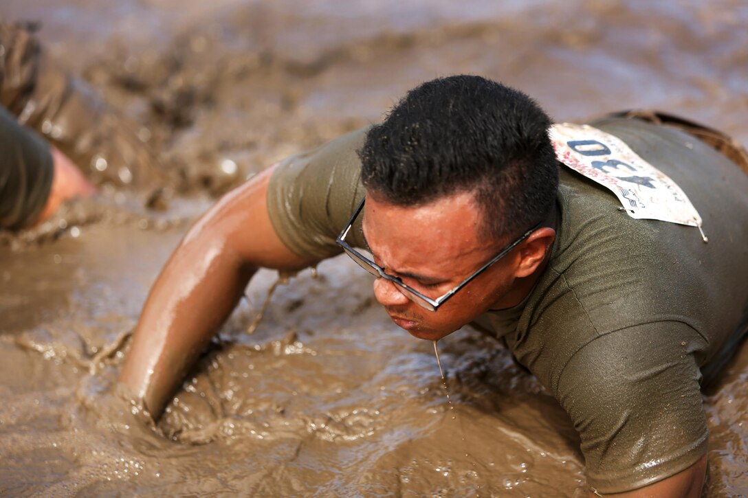A Marine crawls through the mud pit during the 2016 World Famous Mud Run by Lake O'Neill at Camp Pendleton, Calif., June 3, 2016. Marine Corps photo by Pfc. Liah Kitchen