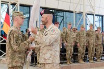 U.S. Army Brig. Gen. John Novalis, left, the deputy commanding general for support for the Combined Joint Forces Land Component Command – Operation Inherent Resolve, passes the Kurdistan Training Coordination Center guidon to Italian Col. Stefan Di Sarra, right, the incoming KTCC commander, during a change of command ceremony held near Erbil, Iraq, June 8, 2016. The passing of the guidon between them symbolizes the Italian coalition partners accepting command of the KTCC. The KTCC is one of four Combined Joint Task Force – Operation Inherent Resolve building partner capacity locations dedicated to training Iraqi Security Forces. (U.S. Army Photo by Staff Sgt. Peter J. Berardi/Released)