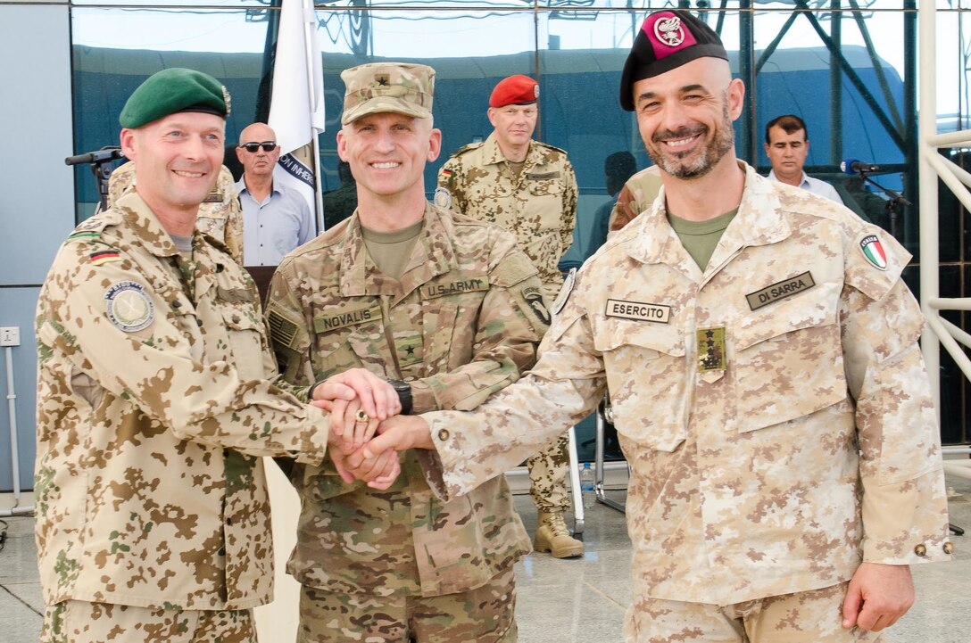 German Col. Bernd Erwin Prill, the outgoing commander of the Kurdistan Training Coordination Center, U.S. Army Brig. Gen. John Novalis, the deputy commanding general for support for the Combined Joint Forces Land Component Command – Operation Inherent Resolve, and Italian Col. Stefan Di Sarra, the incoming KTCC commander, shake hands following the KTCC change of command ceremony held near Erbil, Iraq, June 8, 2016. The ceremony symbolized the German coalition partners passing command of the KTCC to the Italians. The KTCC is one of four Combined Joint Task Force – Operation Inherent Resolve building partner capacity locations dedicated to training Iraqi Security Forces. (U.S. Army Photo by Staff Sgt. Peter J. Berardi/Released)