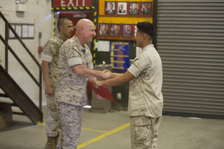 Col. William H. Vivian, left, commanding officer, 7th Marine Regiment presents Lance Cpl. Edwin Salgado, motor transport operator, 7th Marines, the Road Warrior Award in building 1951 aboard Marine Corps Air Ground Combat Center Twentynine Palms, Calif., June 2, 2016. The award is presented to any military or government civilian employee who operates government motor vehicles and achieves mishap or violation-free driving in 2,500-mile increments. (Official Marine Corps photo by Cpl. Medina Ayala-Lo/ Released)