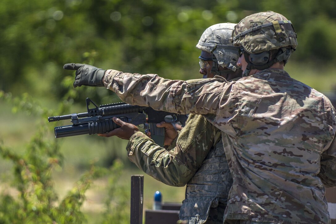 An Army range cadre points out targets downrange to a soldier before firing a M203 grenade launcher on the weapons demonstration range at Fort Jackson, S.C., June 8, 2016. Army photo by Sgt. 1st Class Brian Hamilton