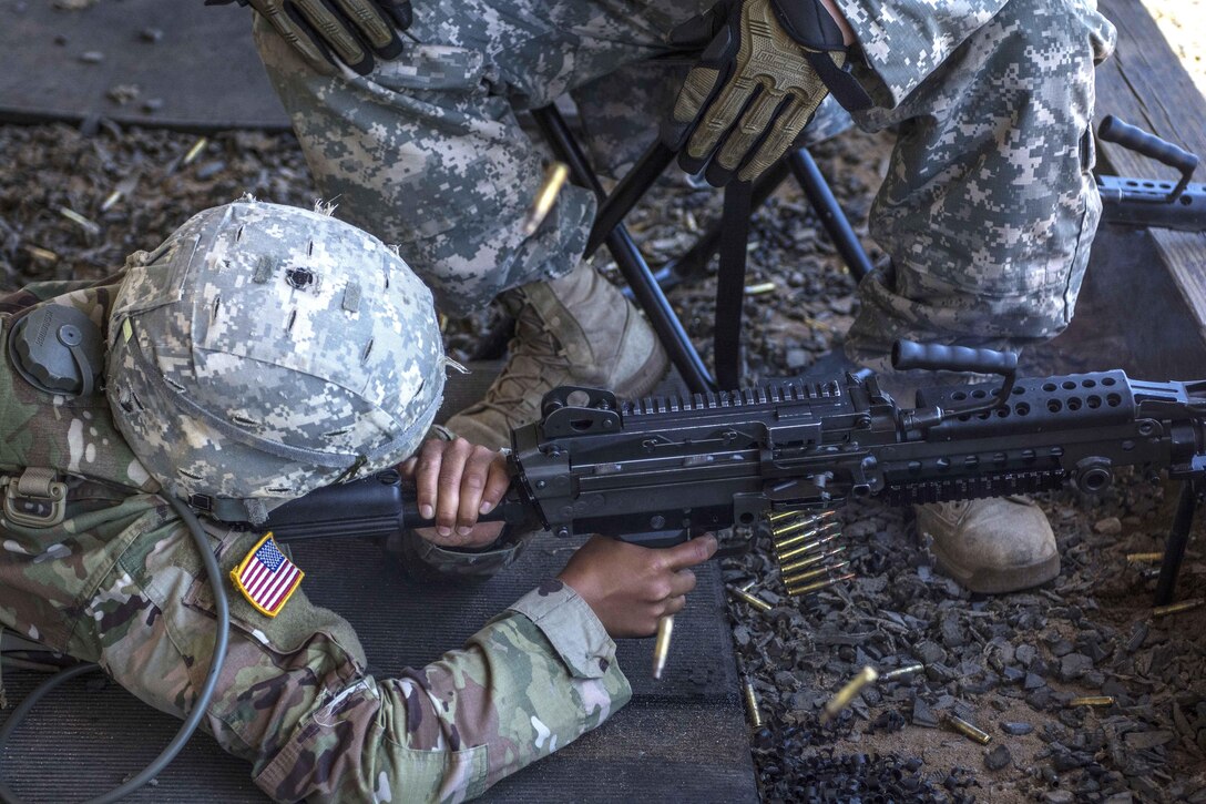 Army Staff Sgt. Zochert, sitting, watches as a soldier fires his M249 light machine gun at targets downrange on the weapons demonstration range at Fort Jackson, S.C., June 8, 2016. Army photo by Sgt. 1st Class Brian Hamilton