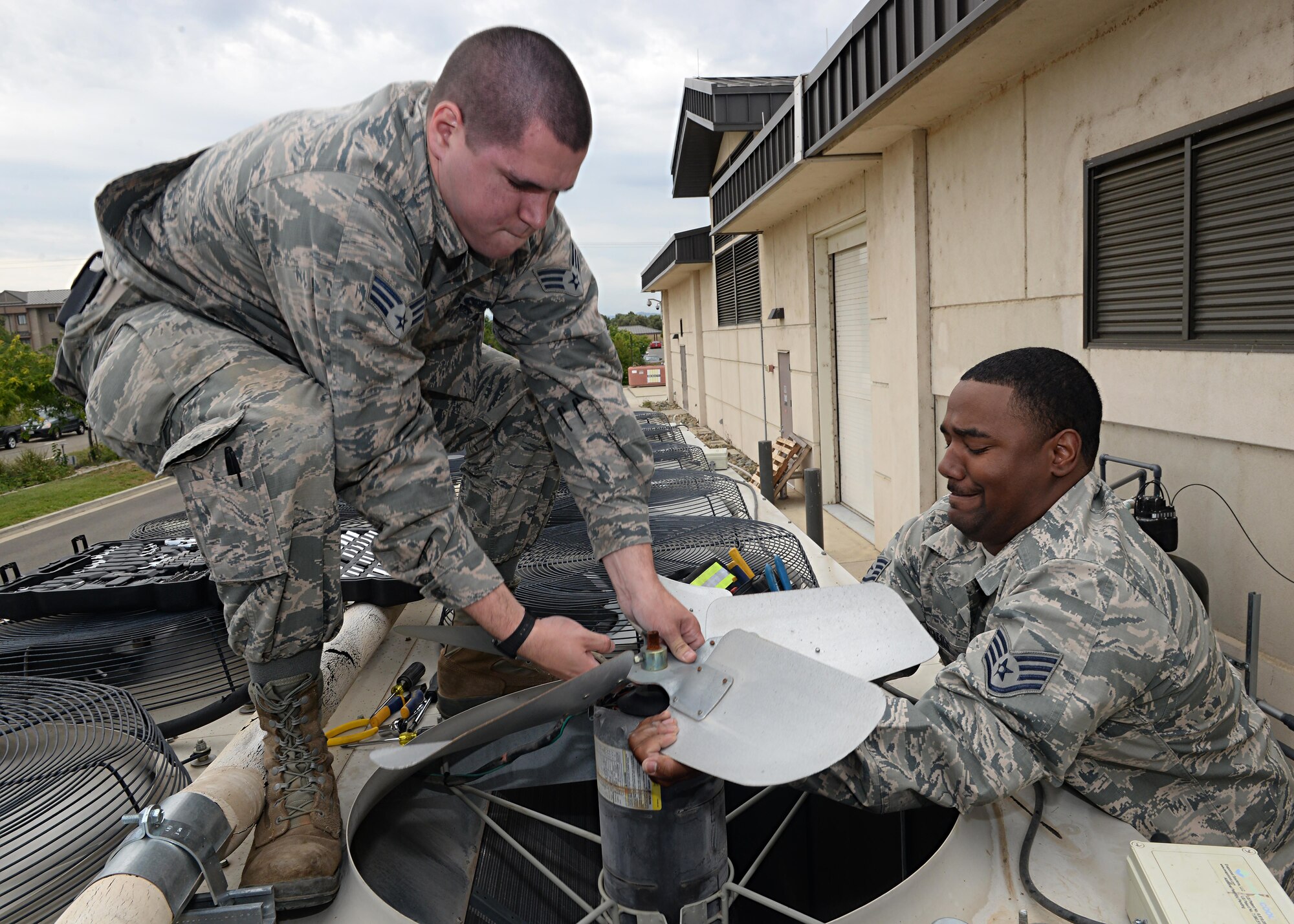 9th Civil Engineer Squadron Heating, Ventilation and Air Conditioning technicians Senior Airman Kyle Cvoliga (left) and Staff Sgt. Yohance Leslie remove a fan and its motor from a HAVC unit May 24, 2016, at Beale Air Force Base, California. The 9th CES HVAC flight maintains the temperature of the operational systems to the Distributed Ground System-2, the RQ-4 Global Hawk fleet’s flight shelters and other global combat influences. If those temperatures rise too high it can cause a halt in mission support.  (U.S. Air Force photo by Senior Airman Ramon A. Adelan)