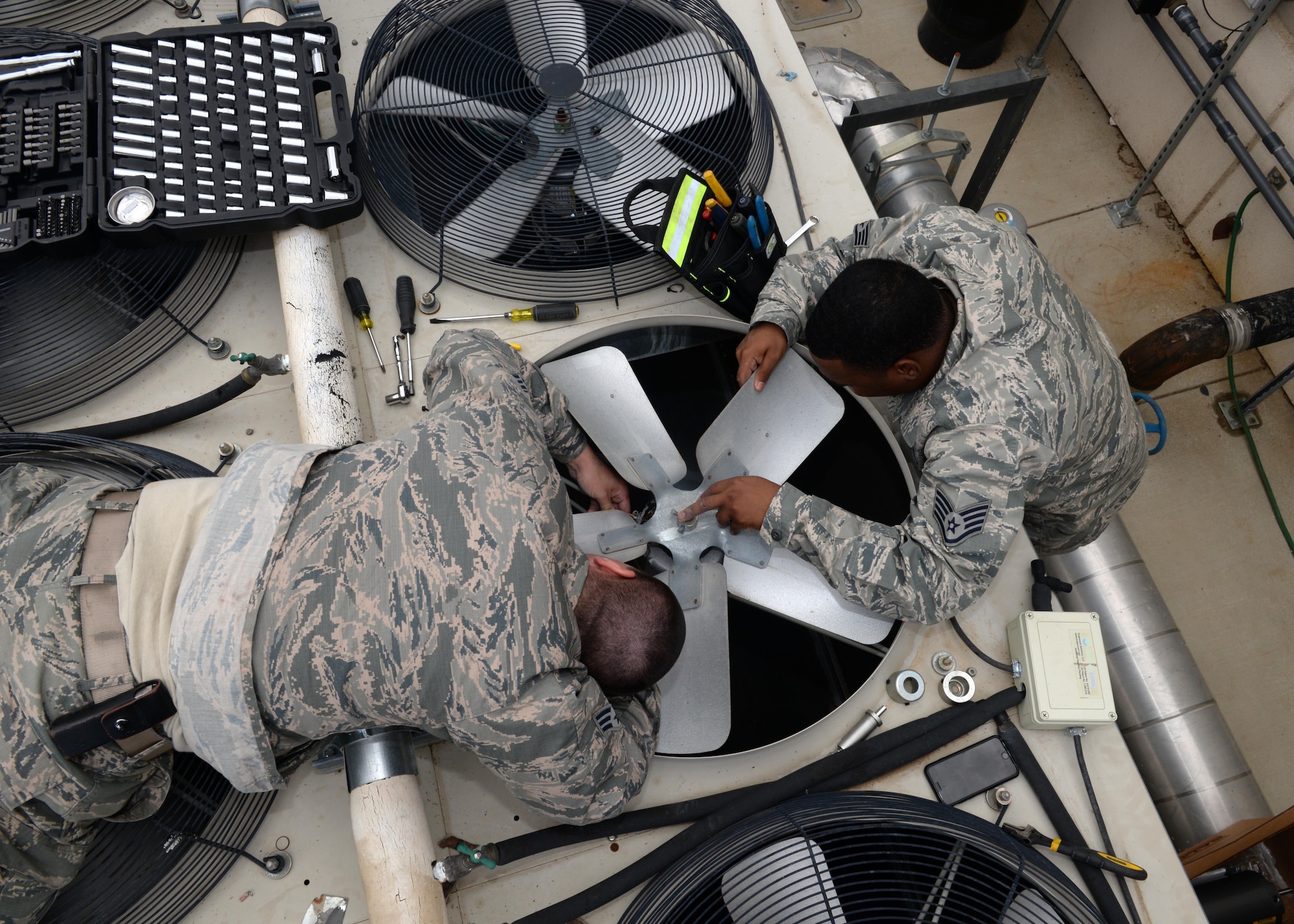 9th Civil Engineer Squadron Heating, Ventilation and Air Conditioning (HVAC) technicians Senior Airman Kyle Cvoliga (left), and Staff Sgt. Yohance Leslie prepare to remove a fan and its motor from a HVAC unit May 24, 2016, at Beale Air Force Base, California. The 9th CES HVAC flight maintains the temperature of the operational systems to the Distributed Ground System-2, the RQ-4 Global Hawk fleet’s flight shelters and other global combat influences. If those temperatures rise too high it can cause a halt in mission support.  (U.S. Air Force photo by Senior Airman Ramon A. Adelan)
