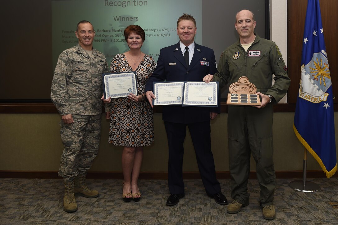 Brig. Gen. Scott Pleus, 56th Fighter Wing commander, poses with the Walk a Mile in Their Shoes contest winners June 7 at Luke Air Force Base, Ariz. The winners from left to right: Tech. Sgt. Barbara Plante, 944th Fighter Wing public affairs and female with the most steps, Tech. Sgt. Karl Clymer, 56 FW safety and male with the most steps, and Col. Jeffrey Mineo, 944 FW director of staff, representing the 944 FW who received the traveling trophy for the overall squadron with the most steps. (Courtesy photo)