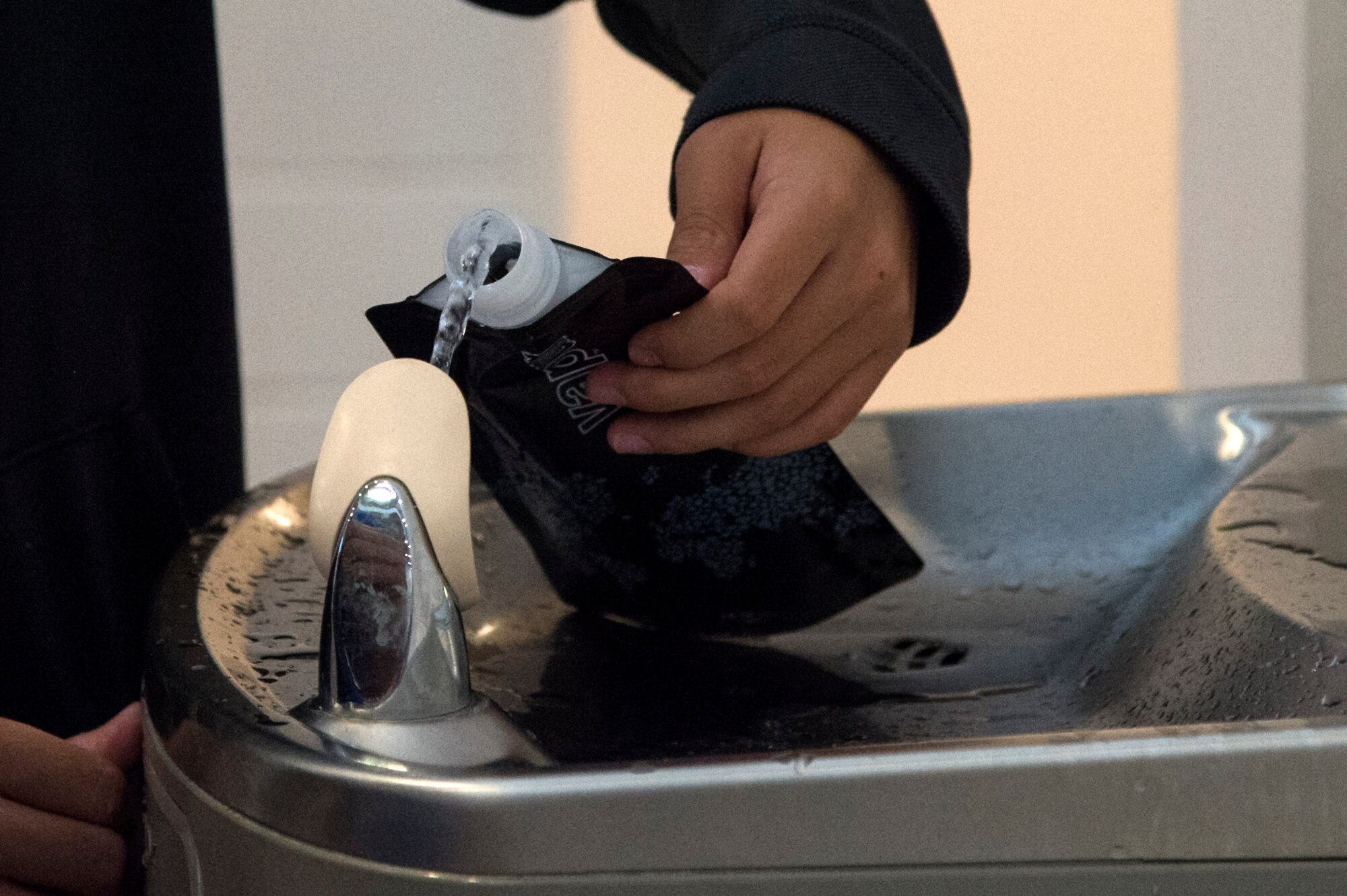 A child from Moody’s Youth Programs fills a water pouch during Olympic Day, June 10, 2016, at Moody Air Force Base, Ga. Children were frequently reminded to hydrate throughout the event to lower the chances of heat-related illnesses. (U.S. Air Force photo by Airman 1st Class Janiqua P. Robinson/Released)