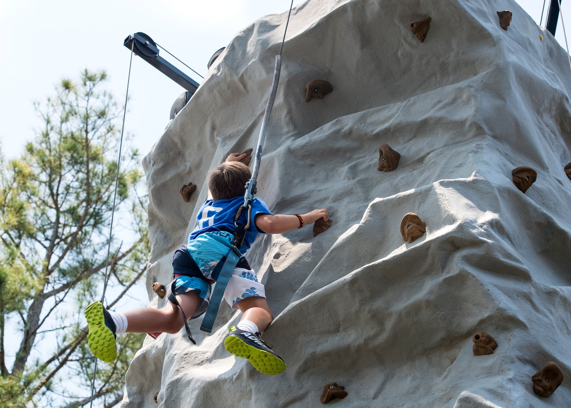 A child from Moody’s Youth Programs climbs a wall during Olympic Day, June 10, 2016, at Moody Air Force Base, Ga. Olympic Day focuses on the Olympic values and ideals such as fair play, perseverance, respect and sportsmanship. (U.S. Air Force photo by Airman 1st Class Janiqua P. Robinson/Released)