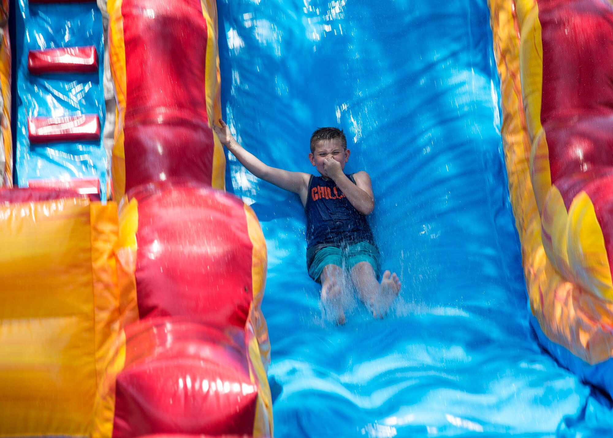 A child from Moody’s Youth Programs rockets down a water slide during Olympic Day, June 10, 2016, at Moody Air Force Base, Ga. This is the third year Exceptional Family Member Program and Youth Programs have participated in the global Olympic Day initiative. (U.S. Air Force photo by Airman 1st Class Janiqua P. Robinson/Released)