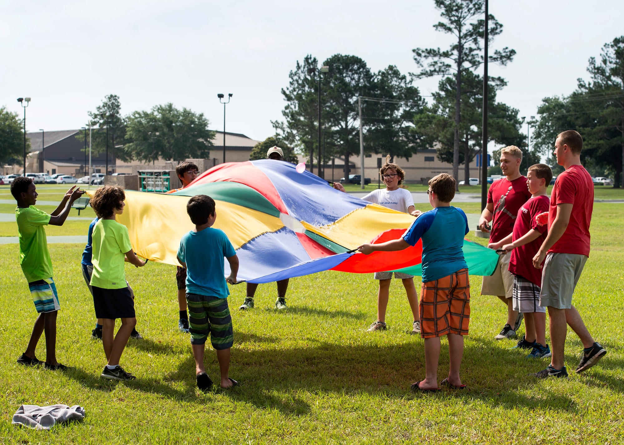 Children from Moody’s Youth Programs try to keep a water balloon on top of a parachute during Olympic Day, June 10, 2016, at Moody Air Force Base, Ga. Volunteers set up 13 stations with physical activities ranging from a water balloon relay race to cornhole. (U.S. Air Force photo by Airman 1st Class Janiqua P. Robinson/Released)