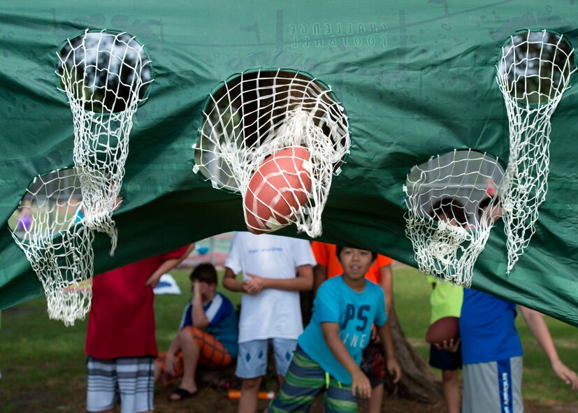 A child from Moody’s Youth Programs throws a football during Olympic Day, June 10, 2016, at Moody Air Force Base, Ga. More than 50 children participated in Moody’s event and all took home a participation medal. (U.S. Air Force photo by Airman 1st Class Janiqua P. Robinson/Released)