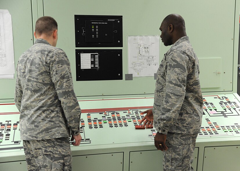 Lt. Col. John Koehler, 10th Space Warning Squadron commander, left, and Col. Rodney Lewis, 319th Air Base Wing commander, right, examine an electrical monitoring system June 11, 2016, on Cavalier Air Force Station, N.D. Community members were given the opportunity to tour the Perimeter Acquisition Radar Attack Characterization System during the Cavalier AFS open house. (U.S. Air Force photo by Senior Airman Ryan Sparks/Released)