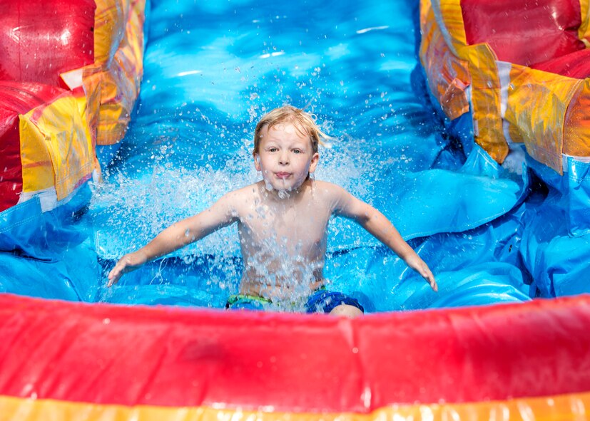 A child from Moody’s Youth Programs slides into a pool of water during Olympic Day, June 10, 2016, at Moody Air Force Base, Ga. Olympic Day was created in 1948 to commemorate the birth of the modern Olympic Games. (U.S. Air Force photo by Airman 1st Class Janiqua P. Robinson/Released)
