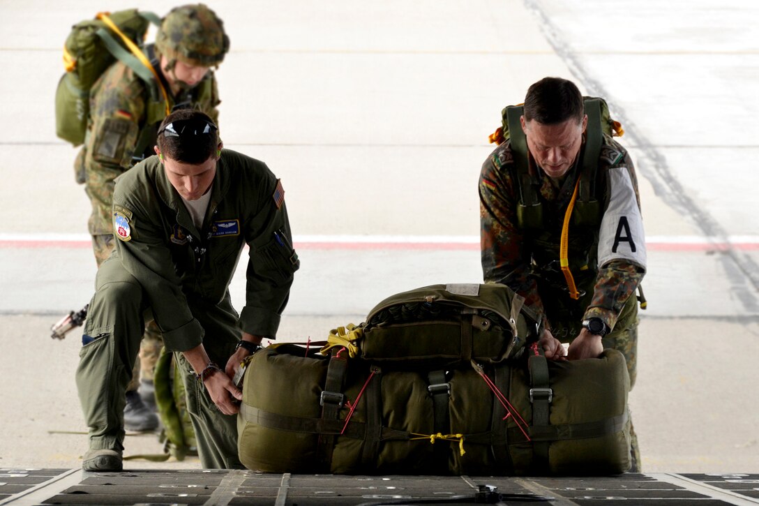 Tech. Sgt. Mark Hanson, 700th Airlift Squadron C-130 Hercules loadmaster and exercise planning cell coordinator, and Capt. Frank Stautz, German special forces jump master, load parachute cargo onto a 94th Airlift Wing C-130 Hercules aircraft in Alberta, Canada, on June 7, 2016, during Maple Flag 49. Paratroopers jumped over Jimmy Lake, Saskatchewan during the international exercise. (U.S. Air Force photo/Master Sgt. James Branch)
