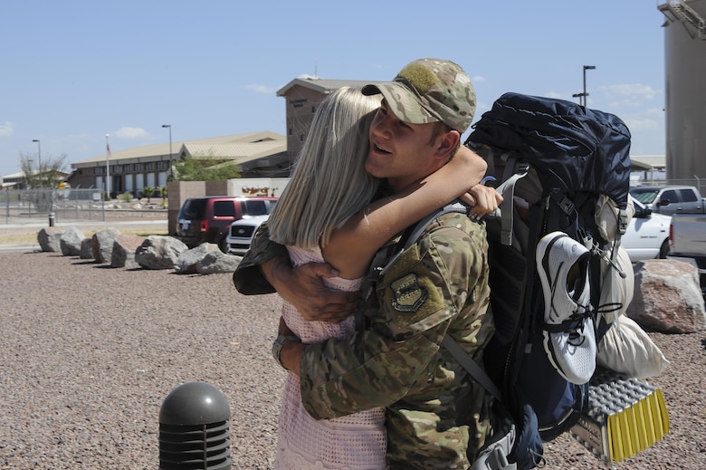 U.S. Air Force Airman 1st Class Bradley, assigned to the 48th Rescue Squadron, hugs his wife after returning home from a 4-month-long deployment at Davis-Monthan Air Force Base, Ariz., June 8, 2016. Two of the three 48th RQS rescue teams, as well as a support team, returned back from a 4-month-long deployment to Turkey. (U.S. Air Force photo by Airman 1st Class Mya M. Crosby/Released)