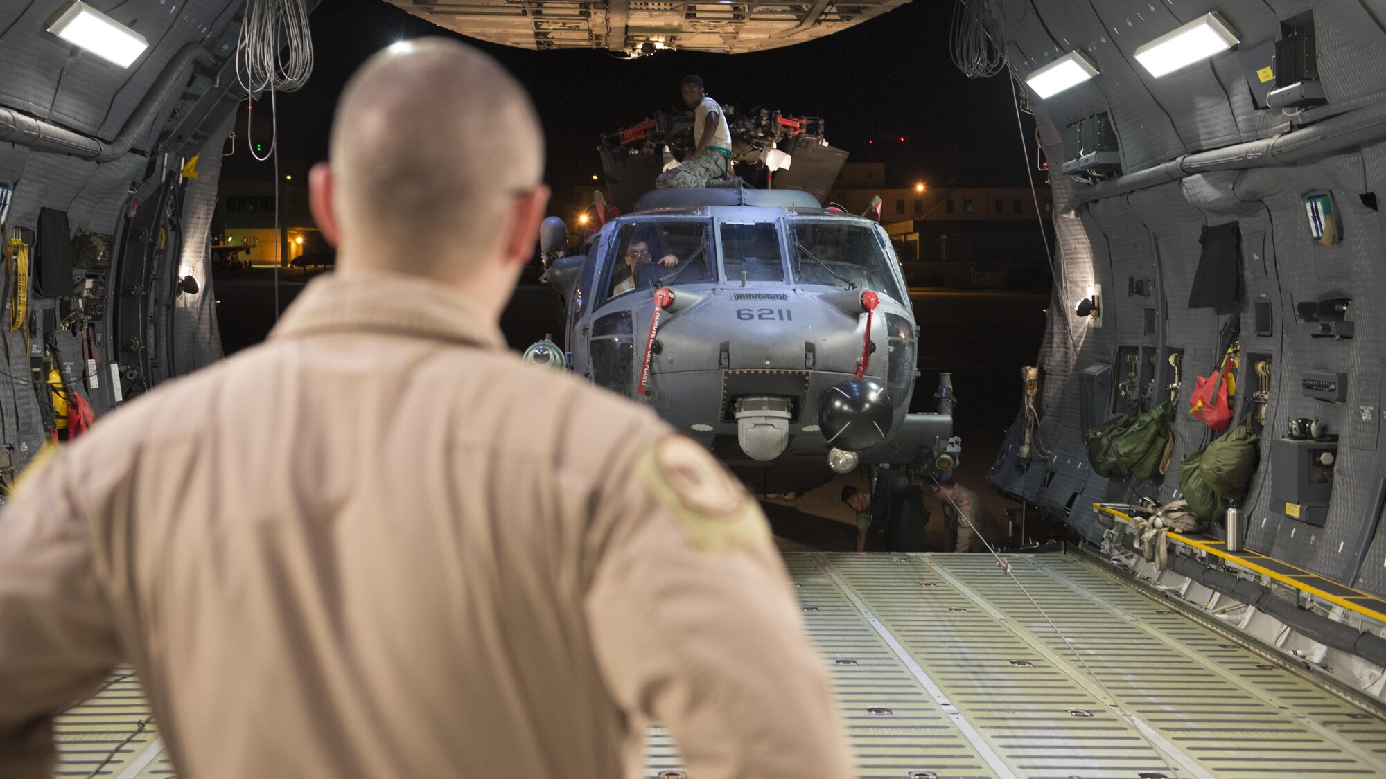Tech. Sgt. Will Russell, 9th Airlift Squadron loadmaster evaluator, supervises the on-load of a HH-60 Pave Hawk into a C-5M Super Galaxy May 26, 2016, at Kadena Air Base, Japan. Russell and three other loadmasters loaded two helicopters and several pallets. (U.S. Air Force photo/Senior Airman Zachary Cacicia) 