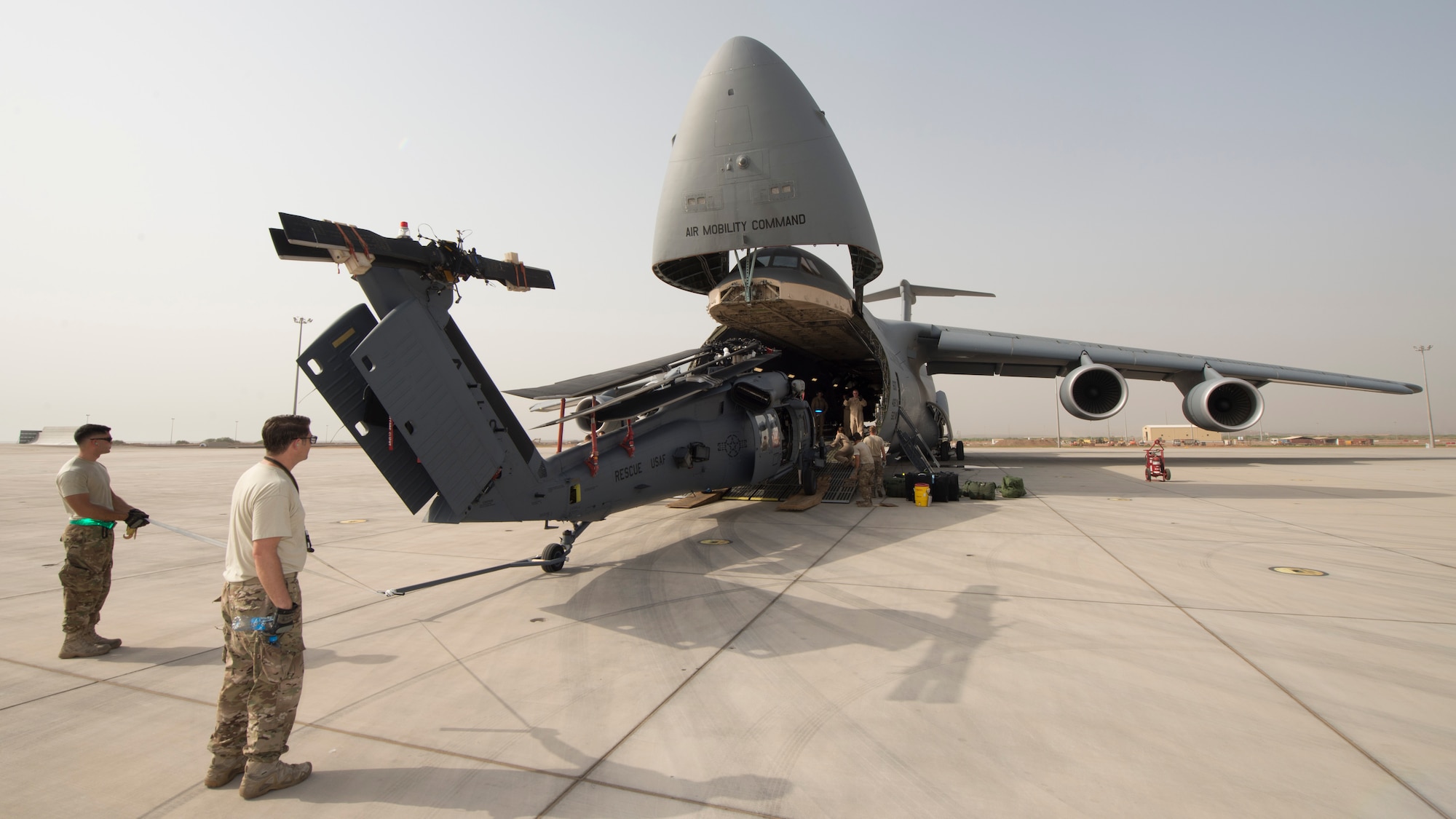 A HH-60G Pave Hawk is off-loaded from a C-5M Super Galaxy May 30, 2016, at Camp Lemonnier, Djibouti. During its mission while circumnavigating the world, this C-5M transported more than 580 thousand pounds of cargo and 398 passengers. (U.S. Air Force photo/Senior Airman Zachary Cacicia)