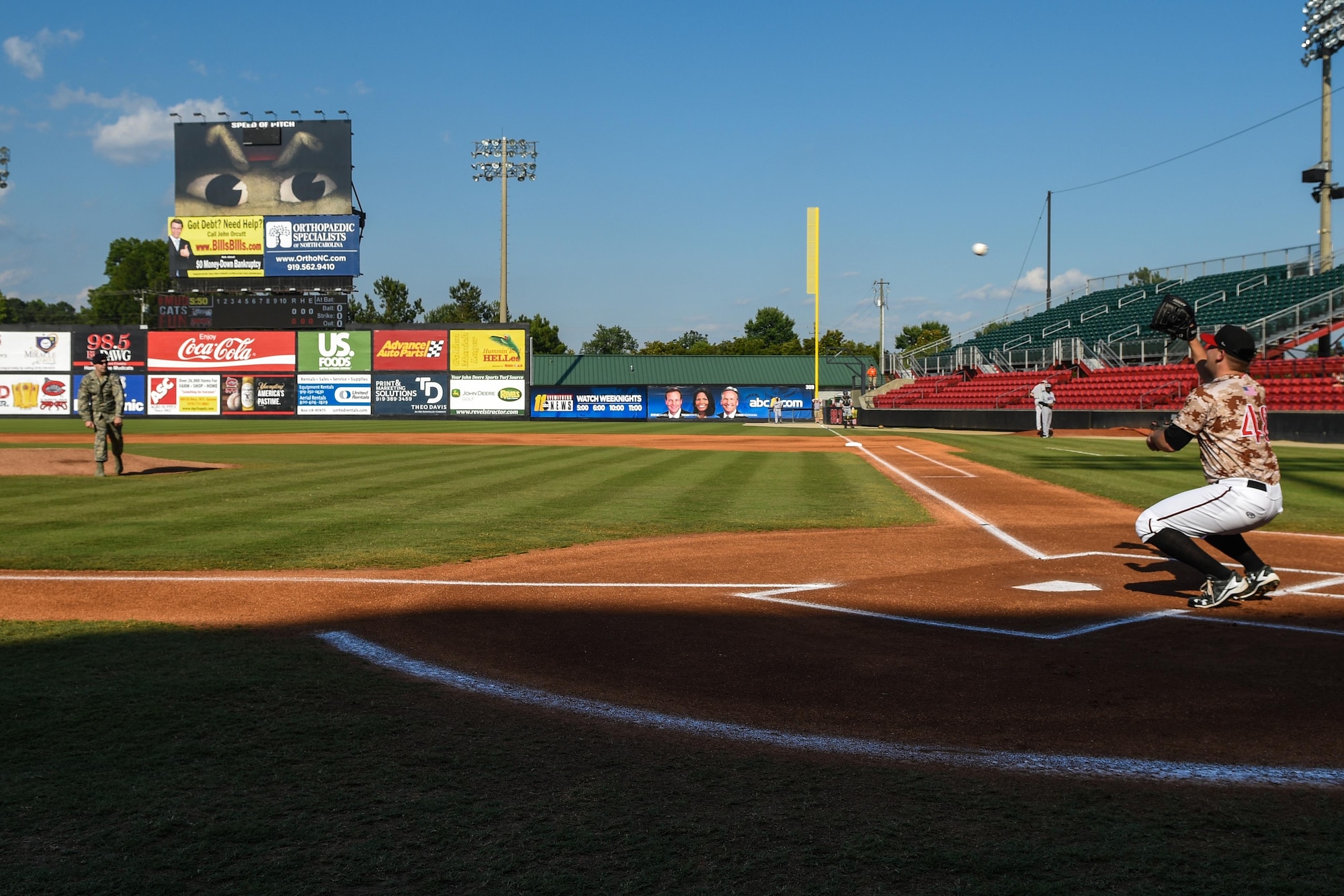 Tech. Sgt. David Kelly (left), 4th Security Forces Squadron anti-terrorism program manager, throws out the first pitch to A.J. Minter, Carolina Mudcats pitcher, June 11, 2016, in Zebulon, North Carolina. The Carolina Mudcats held a military appreciation game and honored Kelly and a Gold Star family during the game. (U.S. Air Force photo by Airman Shawna L. Keyes/Released) 