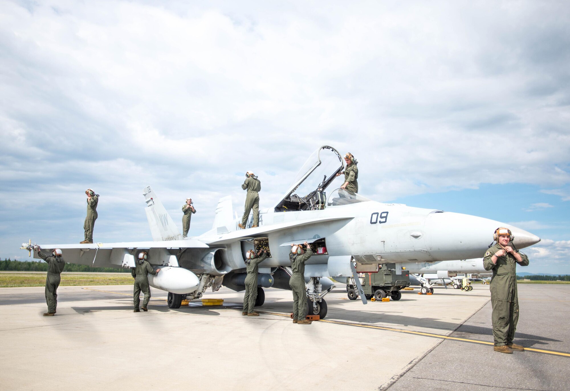 U.S. Marine Corps Sgt. Ian Bennett, Marine Fighter Attack Squadron (VMFA) 314 power line technician, inspects multiple components June 10, 2016, on the number nine jet, which holds the highest flying hours in the U.S. Marine Corps F-18A Hornet inventory, during RED FLAG-Alaska (RF-A) 16-2. Bennett, deployed with the Miramar-based squadron out of California, is one Marine who maintains the jet with more than 9,748 flying hours, which will be retired for parts or another useful purpose shortly after the 10 sorties and travel involved with this RF-A exercise. (U.S. Air Force photo illustration by Staff Sgt. Shawn Nickel/Released)