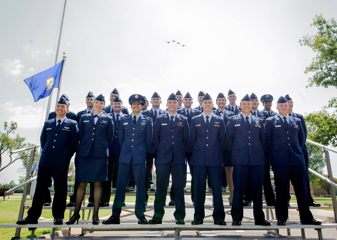 Specialized Undergraduate Pilot Training Class 16-10 graduates at Vance Air Force Base, Oklahoma, pose for family pictures as a four-ship T-6A Texan II formation passes overhead. (U.S. Air Force photo/ David Poe)