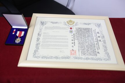 An award ceremony was held June 13, 2016, at Camp Courtney, Okinawa, Japan. U.S. Marine Col. Eric M. Mellinger received an award from Japanese Ground Self-Defense Force Col. Shusei Hotta for significantly contributing to increasing training opportunities for the JGSDF by advancing co-use of Marine Corps training facilities on Okinawa and expanding III Marine Expeditionary Force efforts to participate in alliance/bilateral exercises. Hotta, the deputy chief of Policy and Programs Division, Ground Staff Office, JGSDF, presented the award on behalf of Gen. Kiyofumi Iwata, the JGSDF chief of staff. Mellinger is the III MEF chief of staff.