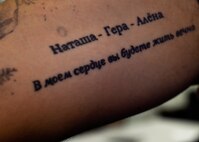 Airman 1st Class Evan Hittle, a 437th Aircraft Maintenance Squadron instrument and flight control systems specialist, uses a tattoo on his arm to remember his family and life in Ukraine. The tattoo has his parents and sister’s names and the words, “In my heart you live forever,” in Russian. (U.S. Air Force Photo/Airman Megan Munoz)