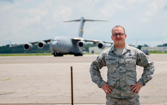 Airman 1st Class Evan Hittle, a 437th Aircraft Maintenance Squadron instrument and flight control systems specialist, stands in front of a C-17 Globemaster III aircraft at Joint Base Charleston, June 11, 2016. Hittle was five-years-old and his sister was seven when their parents passed away and they were orphaned in the Ukraine. A few years later, Hittle and his sister were adopted in the U.S. and transitioned to a new life. Hittle now plans to make the U.S. Air Force a career. (U.S. Air Force Photo/Airman Megan Munoz)