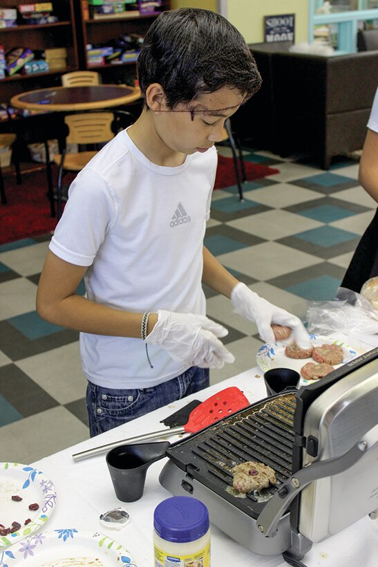 Patrick Liddy creates his signature dish during the Youth Centers Iron Chef Competition. The challenge is the culminating event for students after 12 weeks learning to cook. (Photo by Bud Cordova)
