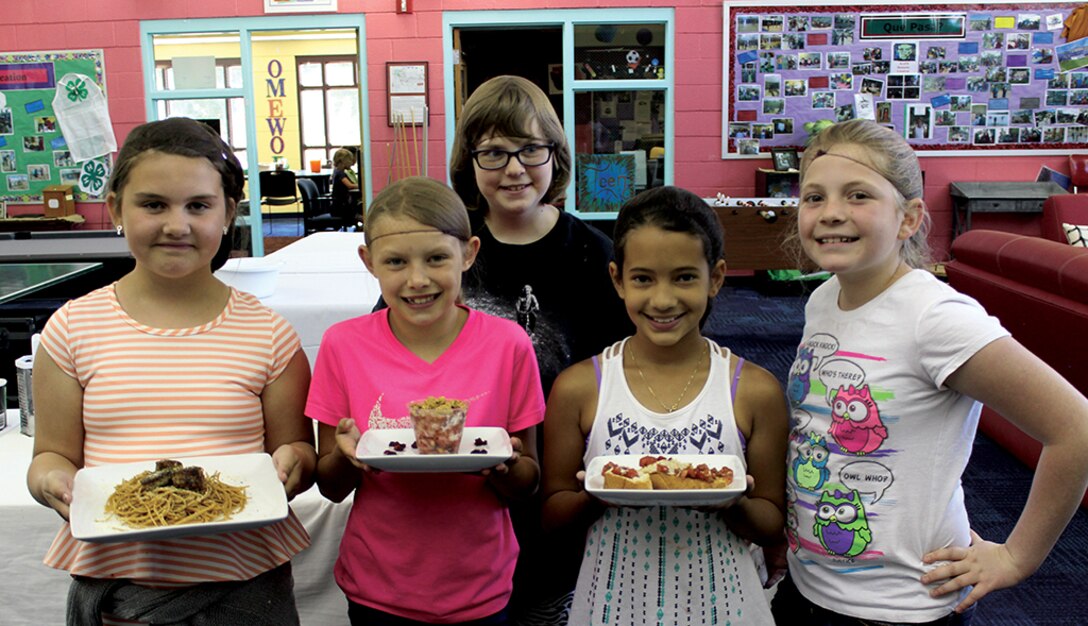 From left to right, Genevieve Wilkinson, Kaylee Phillips, Isaballa Elam, back, Natasha Liddy, and Rhianna Manes members of the winning team for the Youth Centers “Iron Chef Competition. The challenge is the culminating event for students after 12 weeks learning to cook. (Photo by Bud Cordova)