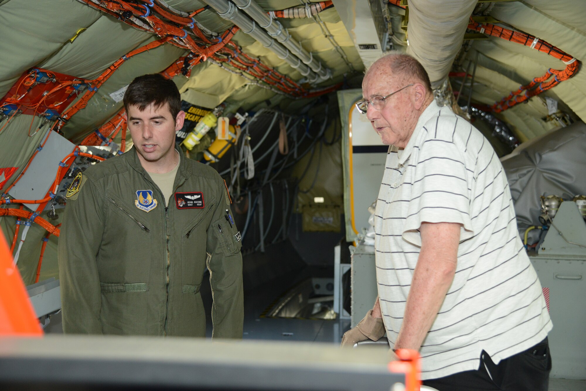 Staff Sgt. Adam Joachim, a test boom operator with the 418th Flight Test Squadron, describes the data-gathering systems and boom operations on a modified KC-135 Stratotanker to retired Maj. Dwight Worden. Worden flew KC-135s for the Air Force  when the service was transitioning from the KC-97 in the 1950s. (U.S. Air Force photo by Christopher Ball.)
