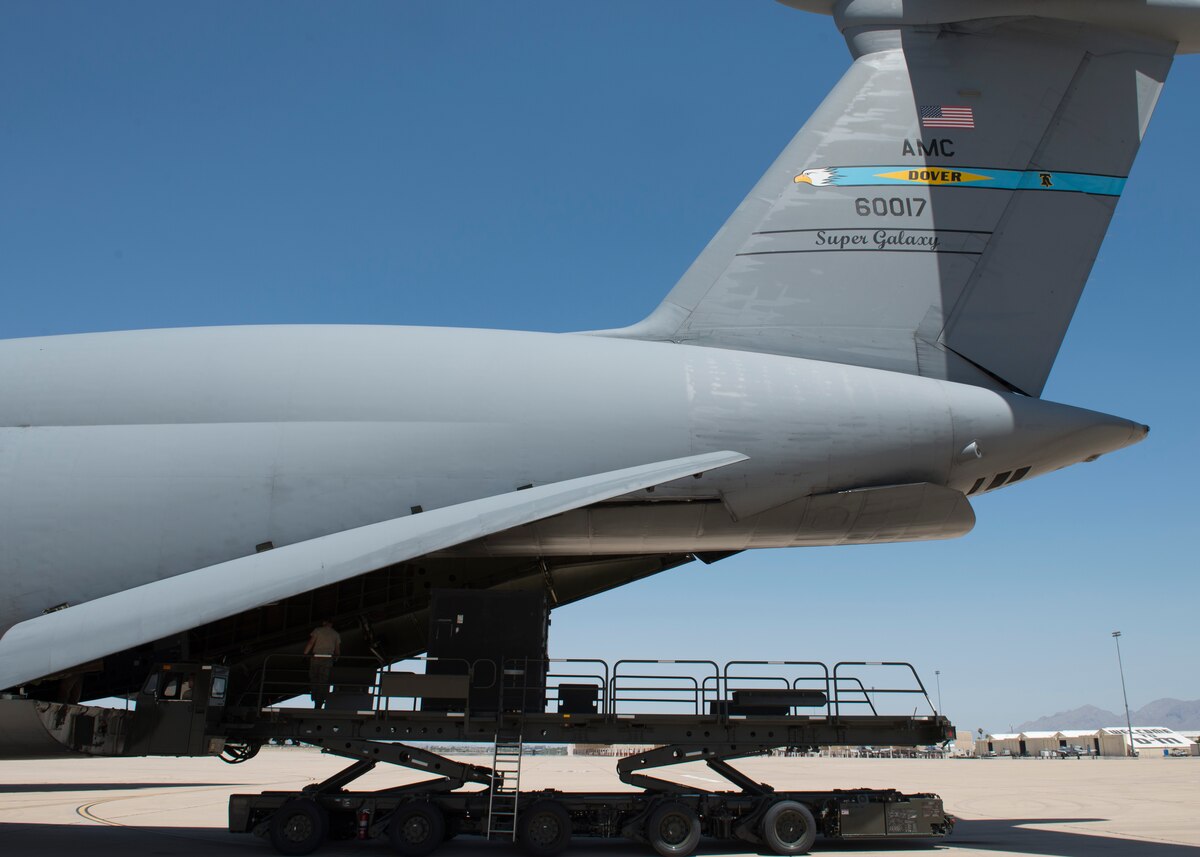 Cargo is off-loaded out of a C-5M Super Galaxy’s rear cargo ramp onto a K-Loader June 2, 2016, at Davis-Monthan Air Force Base, Ariz. Davis-Monthan AFB was the final stop in the circumnavigation mission prior to returning home to Dover AFB, Delaware. (U.S. Air Force photo/Senior Airman Zachary Cacicia)