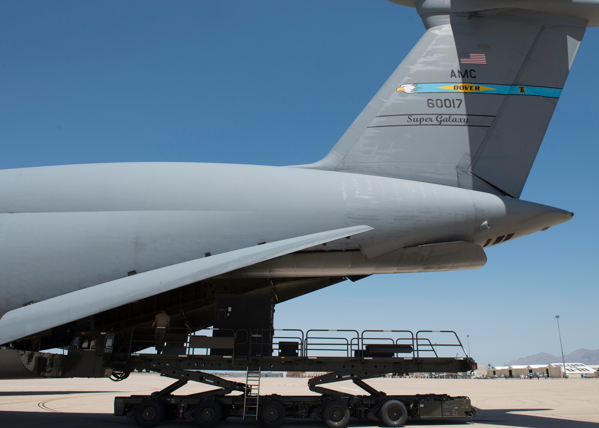 Cargo is off-loaded out of a C-5M Super Galaxy’s rear cargo ramp onto a K-Loader June 2, 2016, at Davis-Monthan Air Force Base, Ariz. Davis-Monthan AFB was the final stop in the circumnavigation mission prior to returning home to Dover AFB, Delaware. (U.S. Air Force photo/Senior Airman Zachary Cacicia)