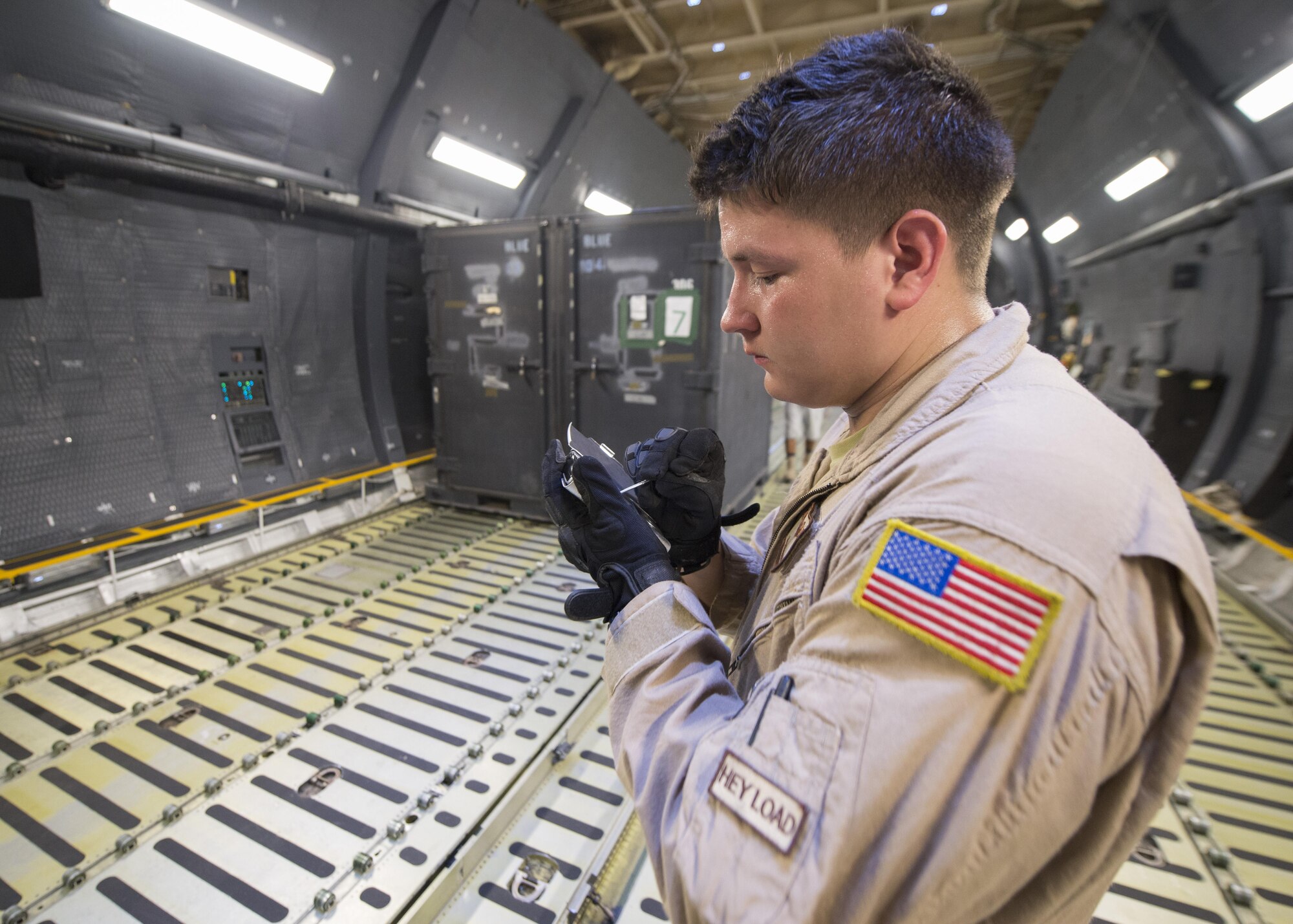 Senior Airman Jesse Garza, 9th Airlift Squadron loadmaster, calculates proper weight and balance into a specialized personal digital assistant during a cargo on-load May 31, 2016, at Camp Lemonnier, Djibouti. Garza was a member of an 11 member aircrew who circumnavigated the globe over a two week period. (U.S. Air Force photo/Senior Airman Zachary Cacicia)
