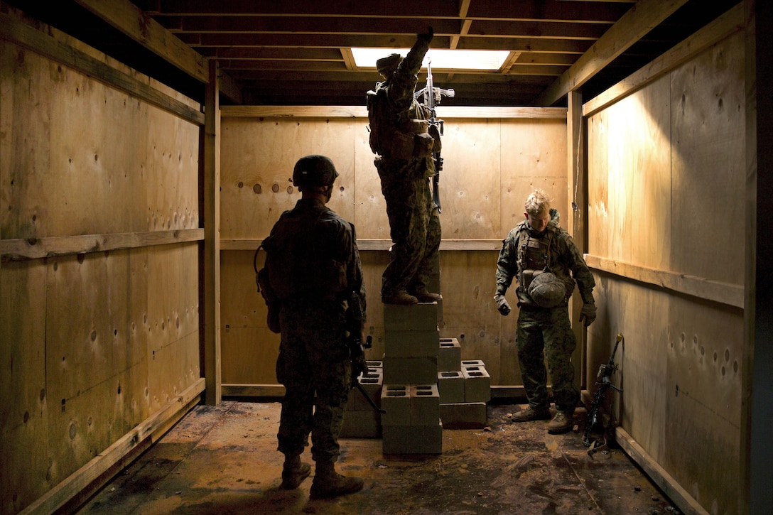 Marines move through the ceiling of a room while clearing a building during Exercise Predator Strike at Cultana Training Area, Australia, June 5, 2016. Marine Corps photo by Cpl. Carlos Cruz Jr.