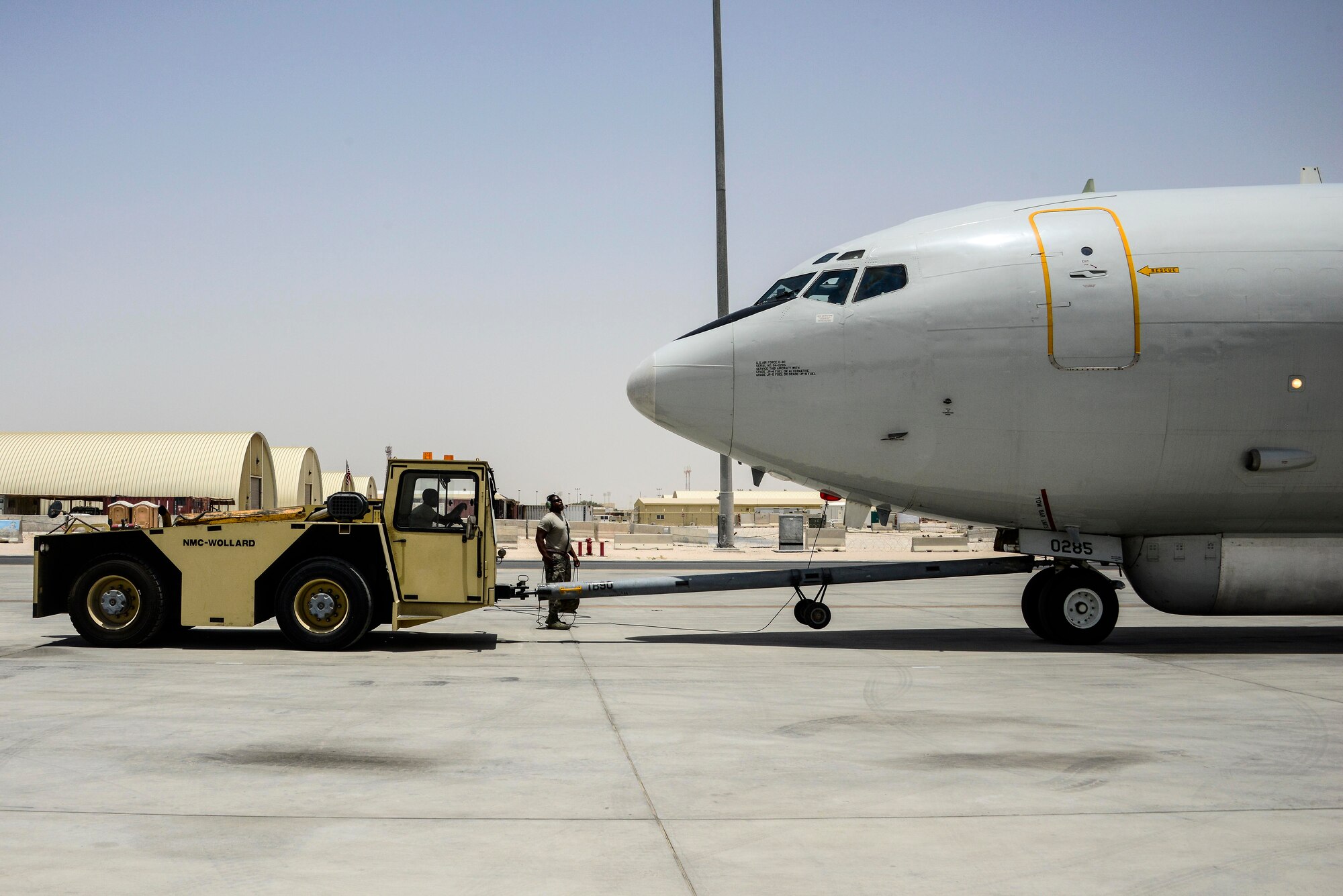 Airman 1st Class Strickland, 7th Air Mobility Unit crew chief, pushes back an E-8C Joint Surveillance Target Attack Radar Systems into its respective parking spot after completing a mission June 7, 2016, at Al Udeid Air Base, Qatar, using a “Uke” MB-2 Tow Tractor. The aircraft contains a radar and computer subsystems that can gather and display detailed battlefield information on ground forces. It can support the full spectrum of roles and missions ranging from peacekeeping operations to major theater war. (U.S. Air Force photo/Senior Airman Janelle Patiño/Released)