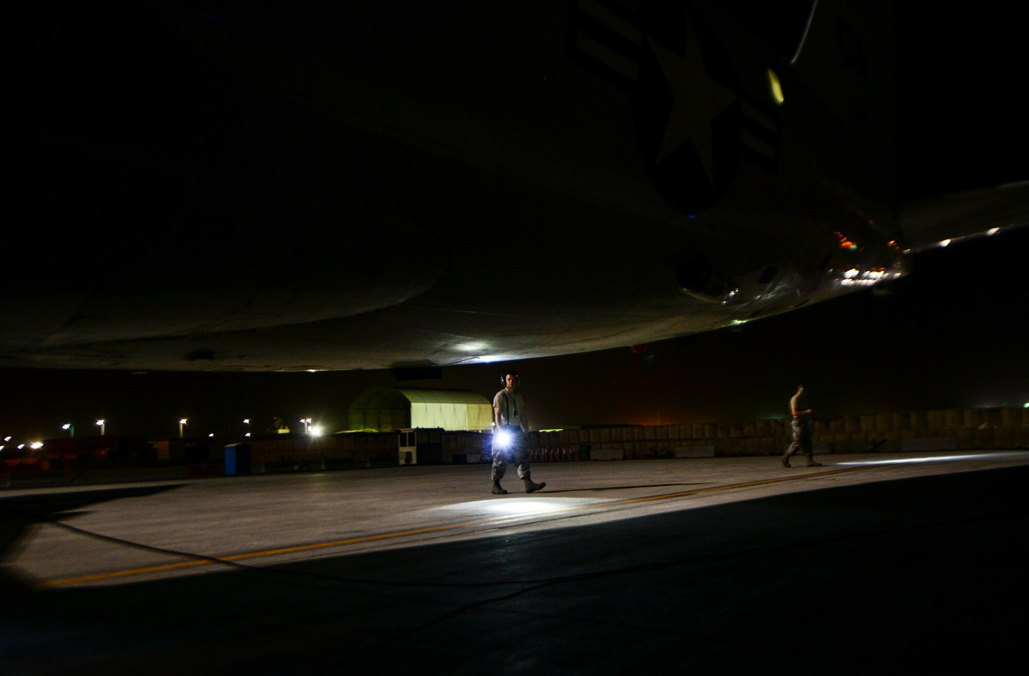 Crew chiefs from the 7th Expeditionary Air Mobility Unit perform a foreign object damage walk prior to the aircraft taxiing in the runway June 8, 2016, at Al Udeid Air Base, Qatar. FOD, or foreign object damage, is a hazard for aircraft and other precision equipment. Suction caused by the air intake of jet engines can pull FOD into the aircraft and cause damage to the high-precision engines and other systems in the aircraft. FOD walks are performed to eliminate danger and problems to the aircraft taxiing down the runway. (U.S. Air Force photo/Senior Airman Janelle Patiño/Released)