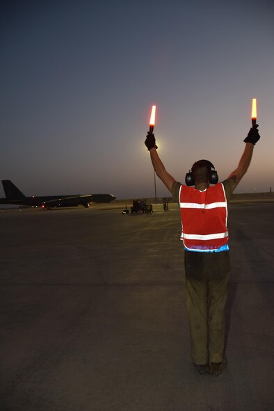 An Airman from 379th Expeditionary Aircraft Maintenance Squadron directs a B-52 Stratofortress to taxi towards him to park at Al Udeid Air Base, Qatar, after a successful bombing mission against Da’esh over Syria and Iraq June 2, 2016. This deployment is the first basing of the B-52s in the U.S. Central Command area of responsibility in 26 years. The B-52s were last based in the region supporting Operation Desert Storm in the early 1990s. (U.S. Air Force photo/Technical Sgt. Carlos J. Treviño/Released)