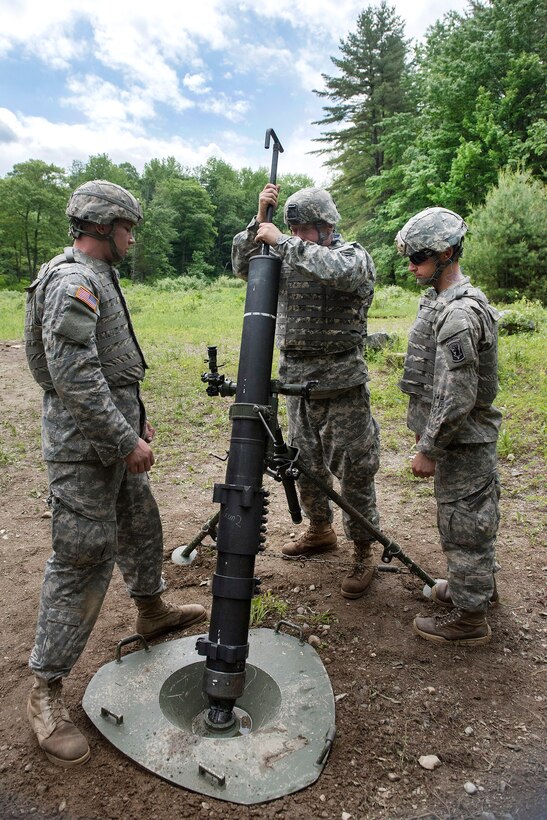 Army Spcs. Craig Smith, left, and Walter Bates, right, watch as Matthew Leighton, center, cleans a mortar system at Camp Ethan Allen training site in Jericho, Vt., June 7, 2016. Smith, Bates and Leighton are mortarmen assigned to the Vermont National Guard’s Company B, 3rd Battalion, 172nd Infantry Regiment, 86th Infantry Brigade Combat Team, Mountain.  Air National Guard photo by Tech. Sgt. Sarah Mattison