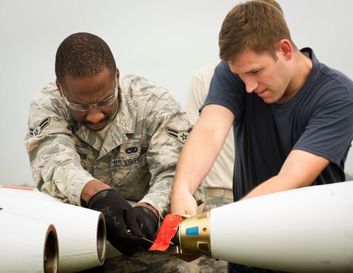 U.S. Airman 1st Class Eric Ligon, 5th Expeditionary Munitions Squadron crew chief, and Petty Officer 2nd Class Ray Charles Newman, Navy Munitions Command Unit Charleston mineman, cut arming wire to a MK-62 Quick Strike inert mine at RAF Fairford, United Kingdom, June 8, 2016. Navy minemen built 12 inert mines for a BALTOPS 16 exercise testing the B-52H Stratofortress’ ability to precisely drop munitions into a target zone. (U.S. Air Force photo/Senior Airman Sahara L. Fales)