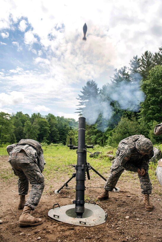 Army Spcs. Craig Smith, left, and Matthew Leighton take cover while firing a mortar system at Camp Ethan Allen training site in Jericho, Vt., June 7, 2016. Smith and Leighton are mortarmen assigned to the Vermont National Guard’s Company B, 3rd Battalion, 172nd Infantry Regiment, 86th Infantry Brigade Combat Team, Mountain.  Air National Guard photo by Tech. Sgt. Sarah Mattison