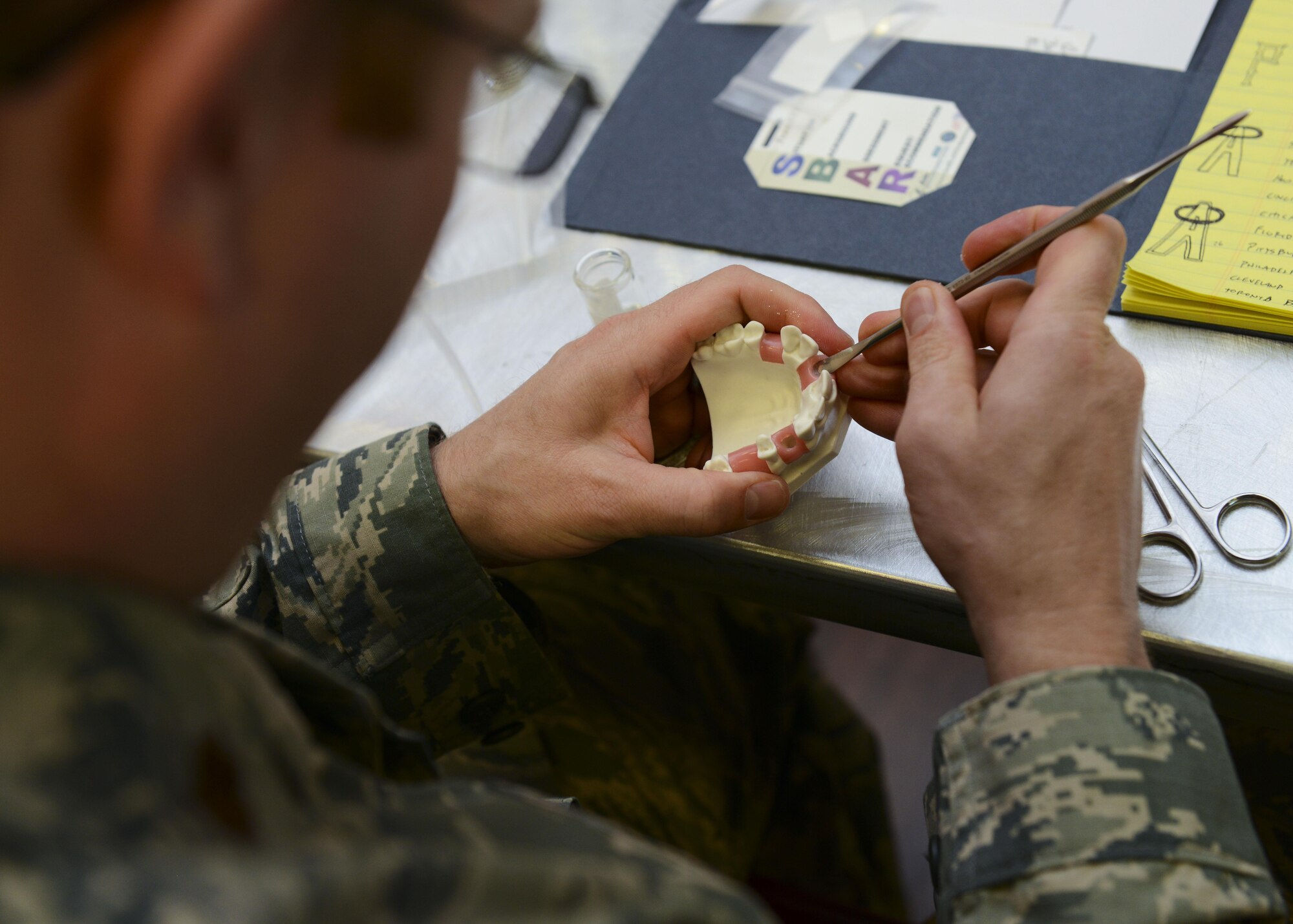 Major Tann Jones, 31st Dental Squadron dentist, manipulates dental putty during a periodontics symposium, June 10, 2016, at Aviano Air Base, Italy. Italian and U.S. military dental professionals gathered at the La Bella Vista Club to learn about new periodontics techniques and technological advances during the symposium. (U.S. Air Force photo by Senior Airman Austin Harvill/Released)