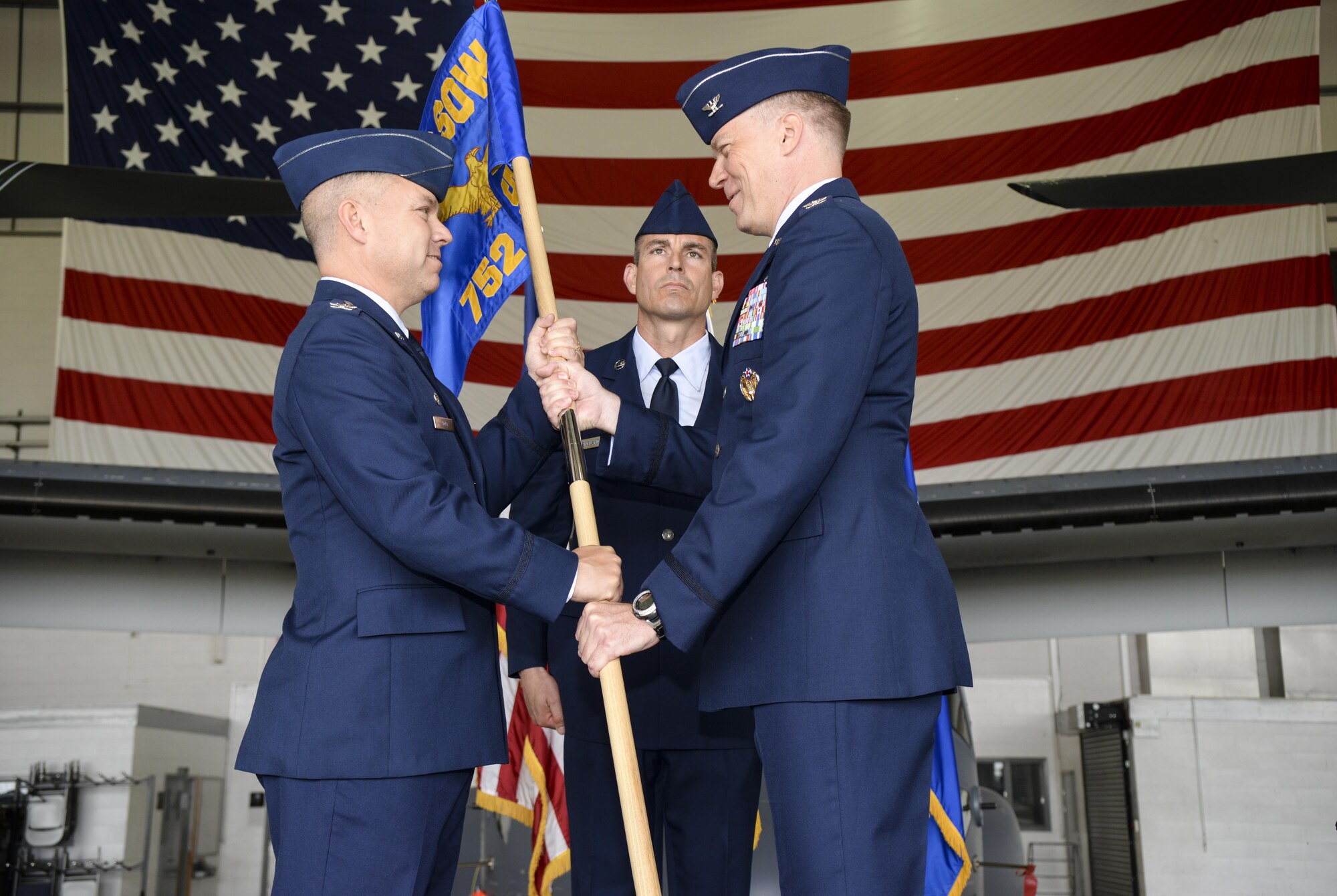 U.S. Air Force Col. William Holt, left, 352nd Special Operations Wing commander, passes the guidon to Col. Lance E. Schmidt, right, incoming 752nd Special Operations Group commander, June 10, 2016, on RAF Mildenhall, England. The passing of the unit guidon during a change of command ceremony is symbolic representation of passing authority to the incoming commander for all to see. (U.S. Air Force photo by Airman 1st Class Tenley Long/Released)