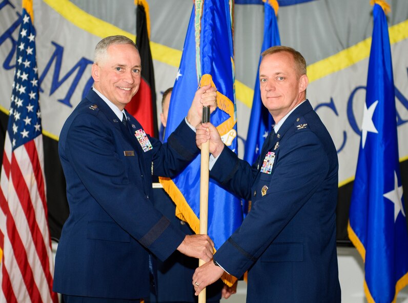 Maj. Gen. Frederick Martin, U.S. Air Force Expeditionary Center commander, passes the 521st Air Mobility Operations Wing flag to Col. Thomas Cooper during a change-of-command ceremony at Ramstein Air Base, Germany, June 14, 2016. With the passing of the flag, Cooper took command of more than 2,000 Airmen throughout Europe and Africa. (U.S. Air Force photo/Staff Sgt. Armando A. Schwier-Morales)