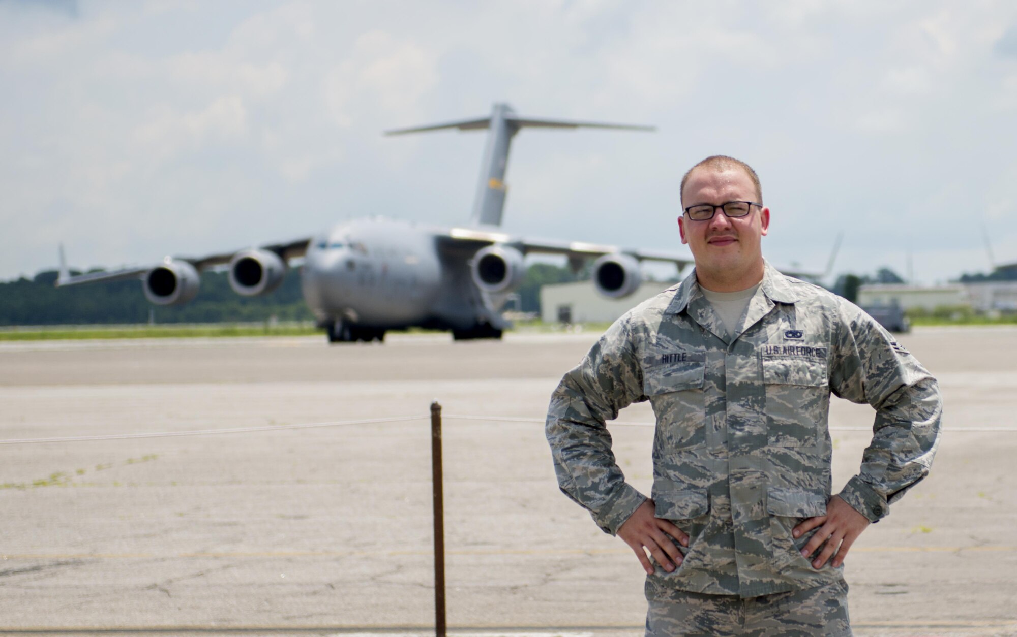 Airman 1st Class Evan Hittle, a 437th Aircraft Maintenance Squadron instrument and flight control systems specialist, stands in front of a C-17 Globemaster III aircraft at Joint Base Charleston, June 11, 2016. Hittle was five-years-old and his sister was seven when their parents passed away and they were orphaned in the Ukraine. A few years later, Hittle and his sister were adopted in the U.S. and transitioned to a new life. Hittle now plans to make the U.S. Air Force a career. 