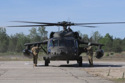 Two UH-60 Blackhawks crew members with the 1-214th Aviation Regiment, Alpha Company, prepare to unload passengers in Warsaw, Poland, June 9, as part of the training exercise Anakonda 2016. Anakonda 2016 is one of U.S. Army Europe's premier multinational training events, which features 24 nations and seeks to train, exercise and integrate Polish national command and force structures into an allied, joint, multinational environment.