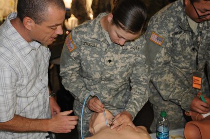 Ted Langevin, a volunteer with CALSTAR, teaches 2nd Medical Brigade Soldier Spc. Jasmaine Rodriguez, A 92G food service specialist From Chico California, the proper method for surgical cricothyrotomy during the annual training exercise at Camp Parks, Calif.  Big Logistics Over-The-Shore, West is an annual, Army Reserve, multi-echelon functional exercise designed for transportation units and sustainment commands to hone their expertise in Logistics Over-the-Shore (LOTS) operations from June 10 to June 24, 2016.  Big LOTS West is a multi-component exercise involving elements from the Active Component Army, U.S. Navy, U.S. Air Force, U.S. Coast Guard, and U.S. Maritime Administration are conducting operations at three Bay-Area California training locations: Camp Parks, Alameda Point, and Coast Guard Island.