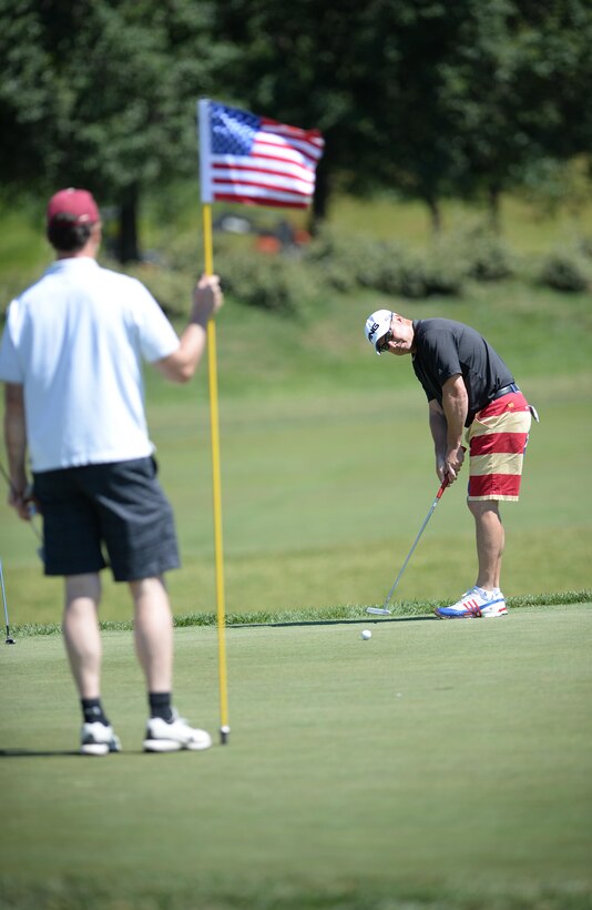 Paul Gorgei putts as teammate Dave Howard tends the flagstick during the 9th Annual ESPN 980 True Heroes Charity Golf Tournament at the 1757 Golf Club in Sterling, Va., June 13, 2016. DoD photo by Marvin D. Lynchard
