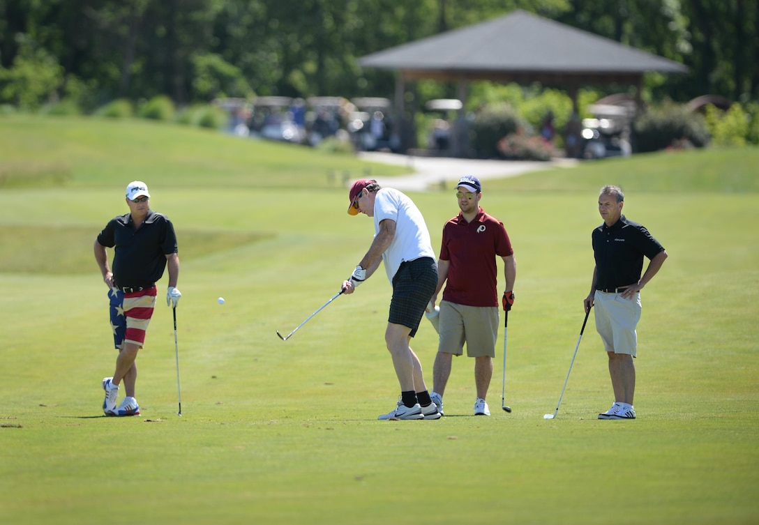 From left, Paul Gorgei, Dave Howard, Matt Anderson and Gary Pesh make approach shots from the fairway during the 9th Annual ESPN 980 True Heroes Charity Golf Tournament to benefit the Purple Heart Foundation at the 1757 Golf Club in Sterling, Va., June 13, 2016 DoD photo by Marvin D. Lynchard