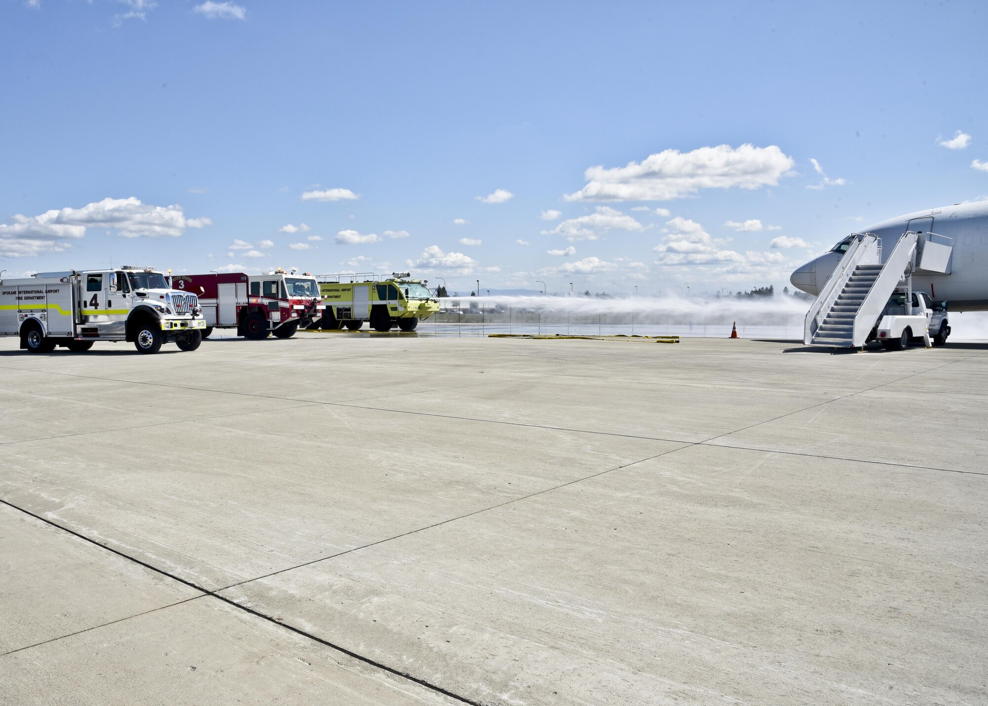 Staff Sgt. Michael Granados and Staff Sgt. Kari Dudoit, 92nd Civil Engineer Squadron firefighters, spray water towards an airplane while two Spokane County firefighters work to retrieve a “victim” from the plane during an exercise June 9, 2016, at Spokane International Airport, Wash. Fairchild's participation is pivotal to the success of any significant risk that our community faces,” said Brian Schaeffer, Spokane Fire Department assistant fire chief. “Their physical resources, personnel and leadership bring unique perspectives the civilian world cannot begin to re-create or replace.”